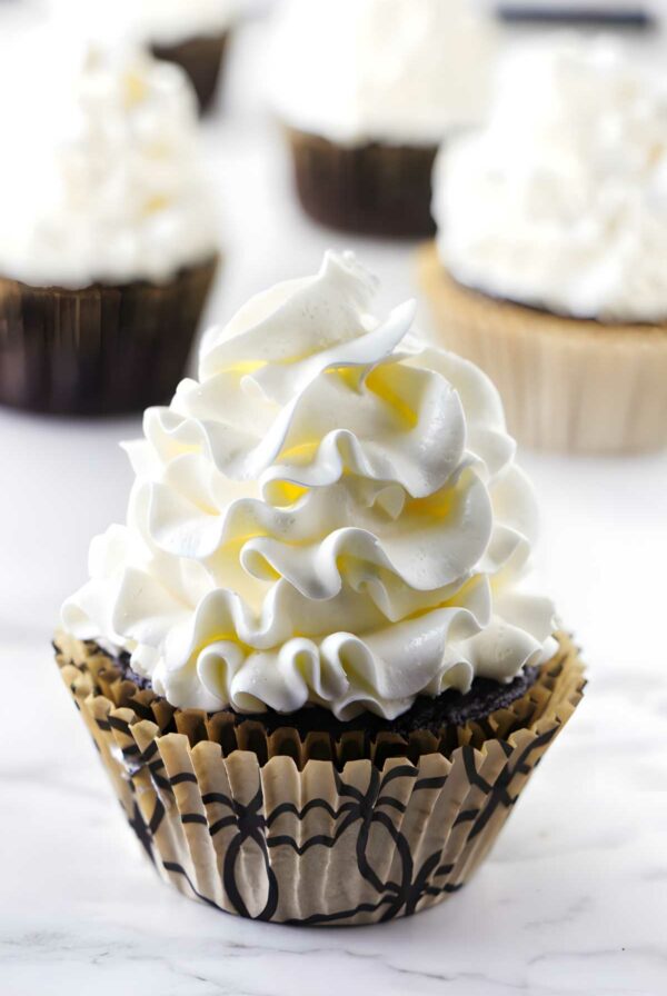 A cupcake with Italian meringue buttercream swirled on top.