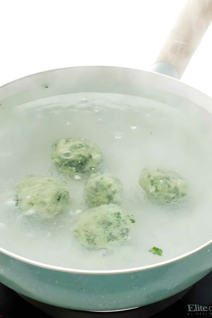 Four ricotta Italian dumplings boiling in steaming water.