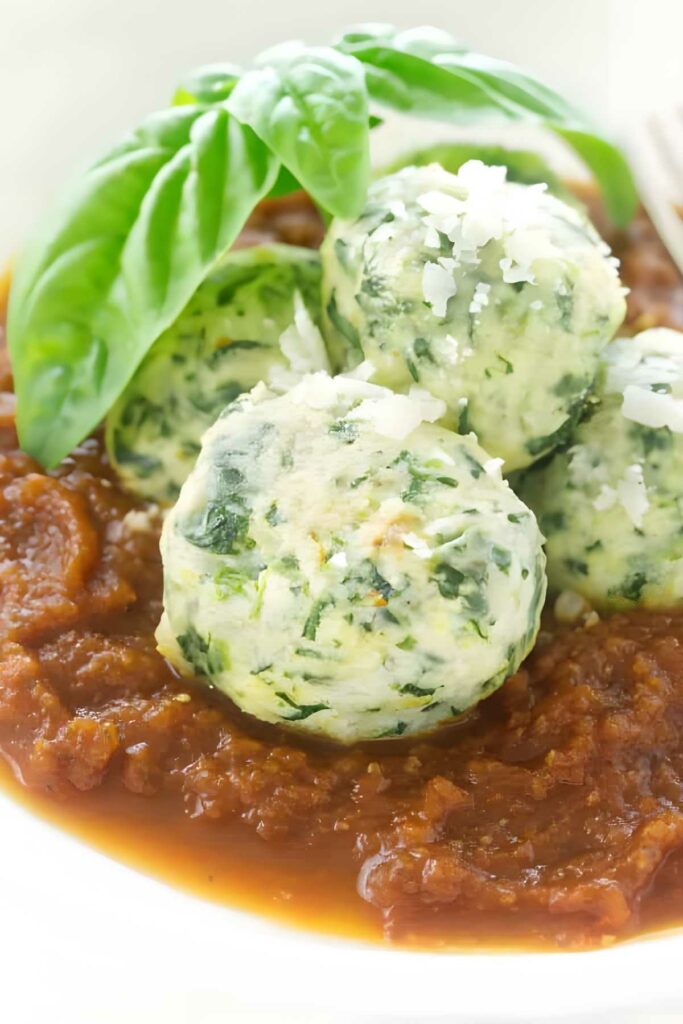 Spinach and ricotta dumplings with cheese, basil, and tomato sauce.