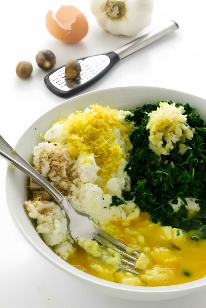 White bowl with ricotta, spinach, zest, garlic.