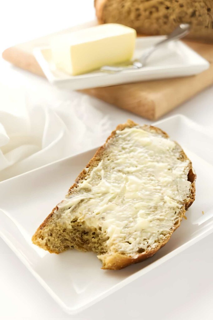 Buttered bread slice with bite. 
