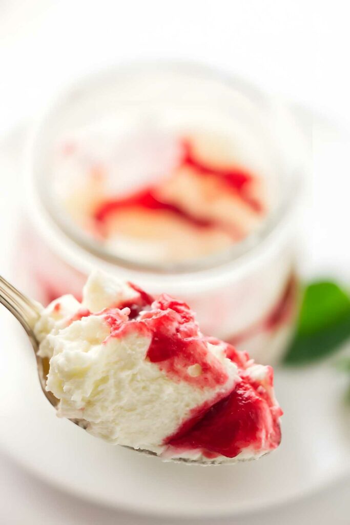 Spoonful of white chocolate mousse with raspberry puree.