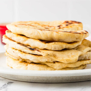 A stack of sourdough flatbread on a white plate.