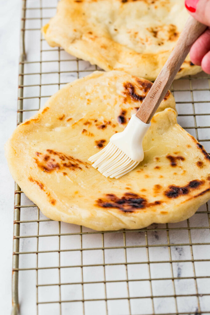 Brushing butter on sourdough flat bread.