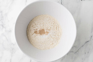 Adding the flour to a bowl to make sourdough griddle bread.