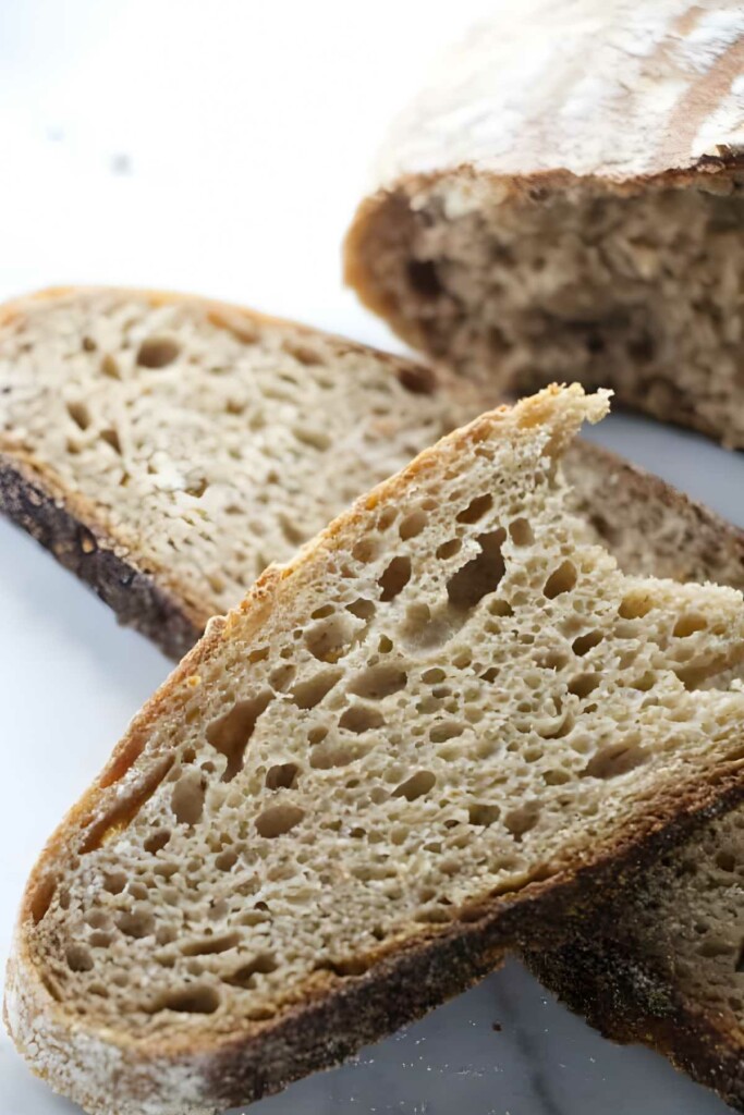 Two slices of rustic sourdough spelt bread with airy crumb.