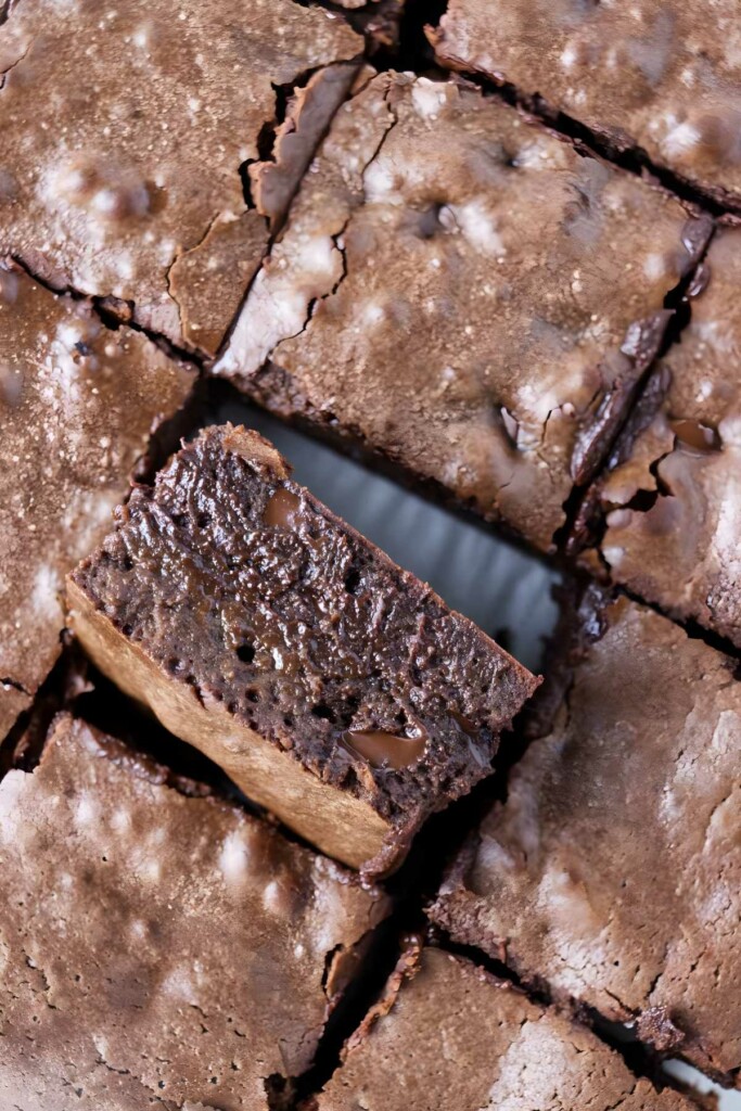 Gooey, sliced condensed milk brownies with shiny cracked tops.