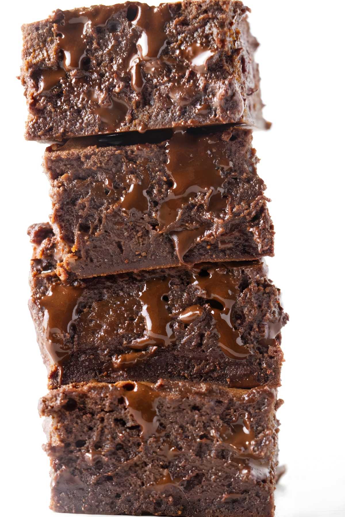 Four stacked condensed milk cocoa brownies drizzled with melted chocolate.