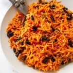 A bowl filled with carrot raisin salad.