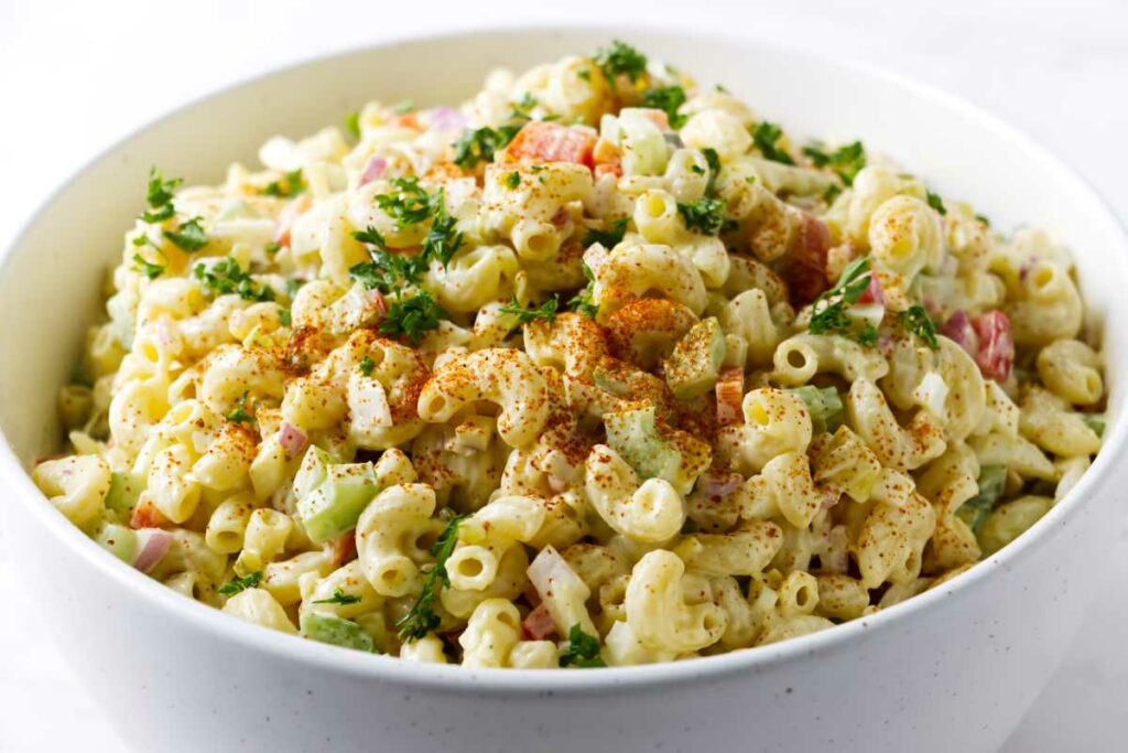 A serving bowl filled with classic macaroni salad.