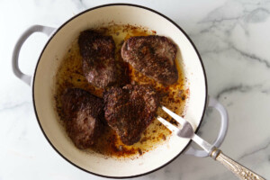 Searing steak in a skillet.