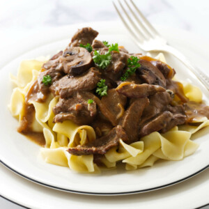 Creamy beef stroganoff with mushrooms and onions, served over a bed of buttered egg noodles.