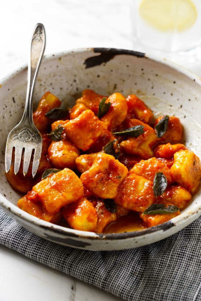 Homemade fresh ricotta gnocchi tossed in tomato sauce in a bowl.
