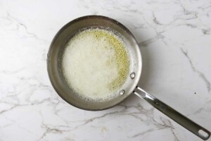 Melted butter in a skillet with foam on top.