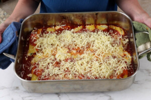 Topping the pasta bake with more cheese.