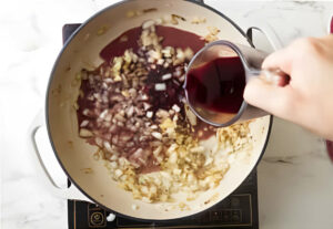 Adding wine to the skillet.