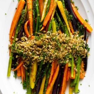 A carrot and asparagus recipe on a white serving platter.