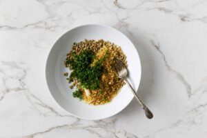 Mixing sunflower seeds and panko in a bowl.