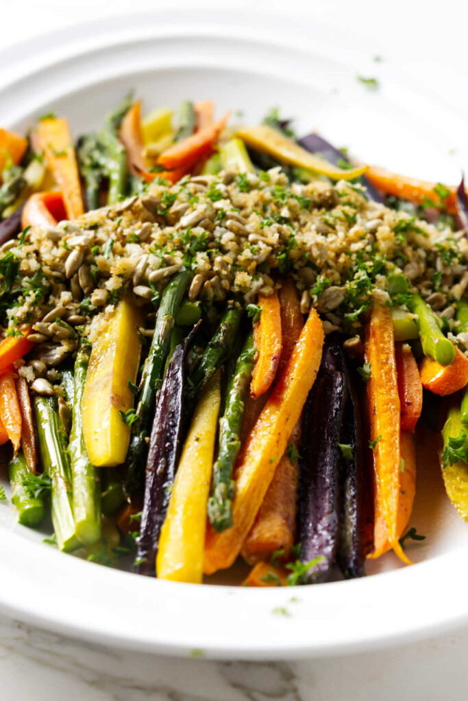 A asparagus and carrots recipe topped with a panko and sunflower seed garnish.
