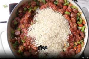 Adding rice and tomato sauce to the peppers.