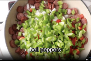 Adding peppers to the rice skillet.