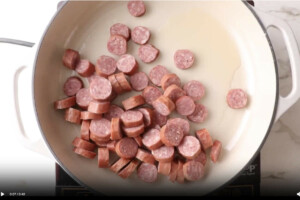 Cooking sausage in a skillet.