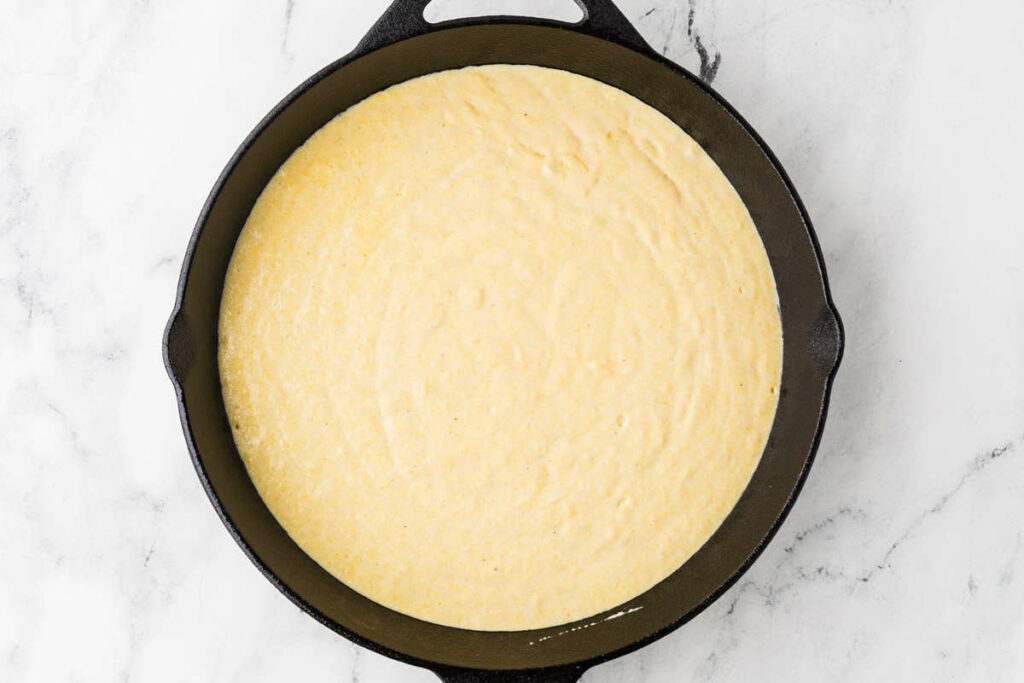 Cornbread batter in a cast iron skillet.