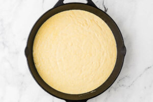 Cornbread batter in a cast iron skillet.