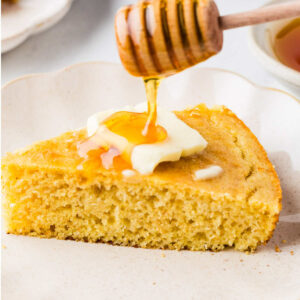 Drizzling honey over a slice of sourdough starter cornbread.