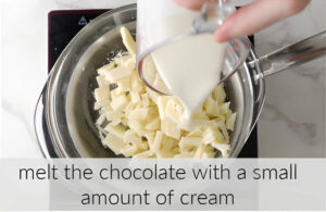 Adding cream to a bowl of chopped white chocolate.