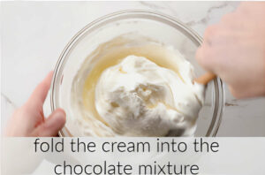 Folding whipped cream into melted white chocolate.