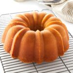 Golden-brown pound cake on cooling rack.