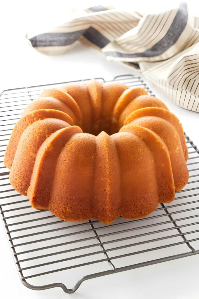 Golden-brown pound cake on cooling rack.