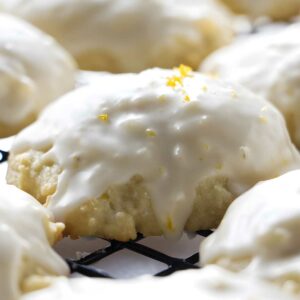Glazed cookies with orange zest cooling on a wire rack.