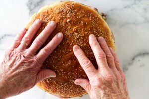 Topping the sandwich with another layer of bread.