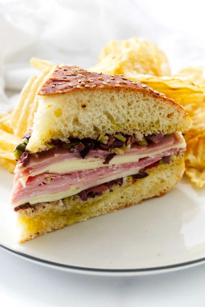 A slice of a cold sandwich with Giardiniera and olives.