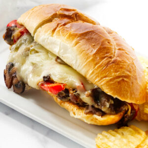 A philly steak and cheese recipe next to potato chips.