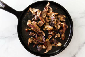 Strips of beef in a skillet for steak and cheese.