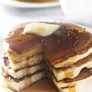 Stack of sourdough ricotta pancakes with butter.