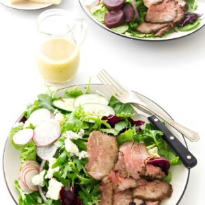 A steak salad made with leftover tri tip on a white counter.