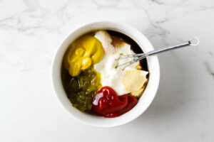Combining ingredients in a bowl to make special sauce for burgers.
