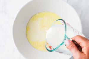 pouring cream into custard for vanilla ice cream.
