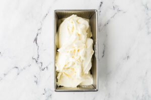 Freshly churned vanilla custard ice cream in a container ready for the freezer.