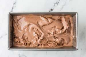 Spreading soft ice cream into a pan to freeze.