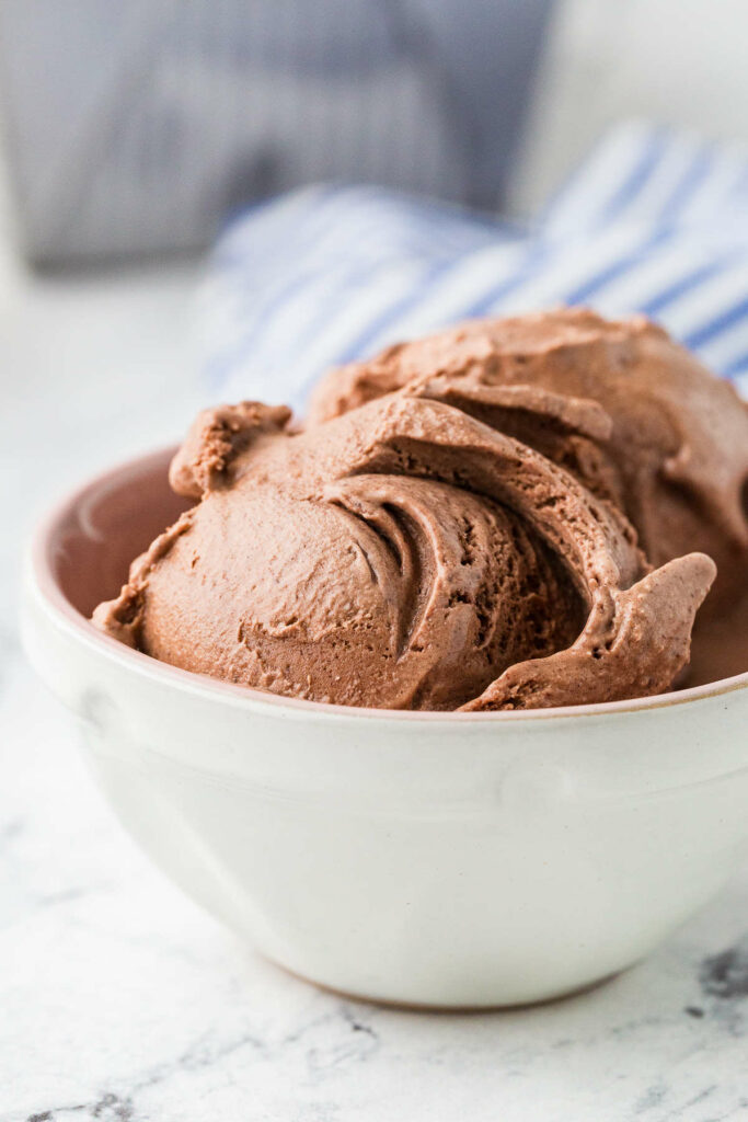A bowl filled with chocolate custard ice cream scoops.