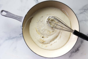 Whisking the roux in a skillet.