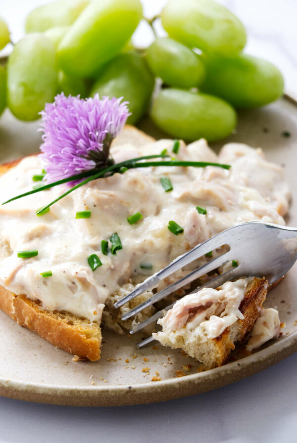 A fork slicing into creamed tuna on toast.