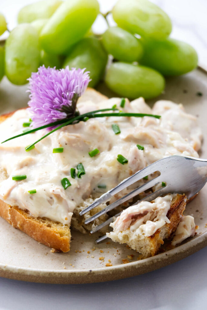 A fork slicing into creamed tuna on toast.