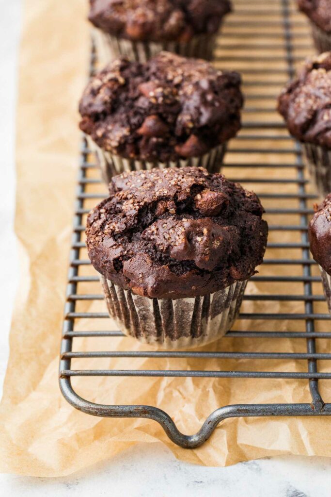 Several muffins on a cooling rack.