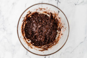 Mixing the chocolate muffin batter in a bowl.